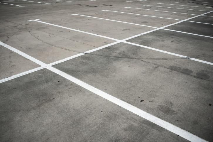 Empty parking spaces marked with white lines on asphalt.