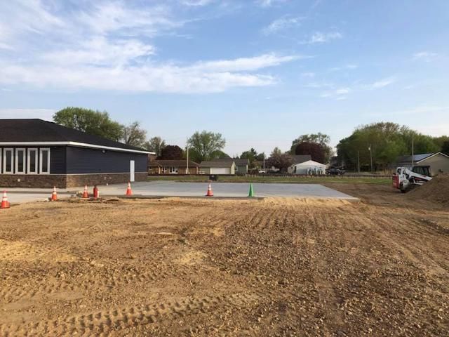 Newly poured concrete slab in front of a building; construction site.