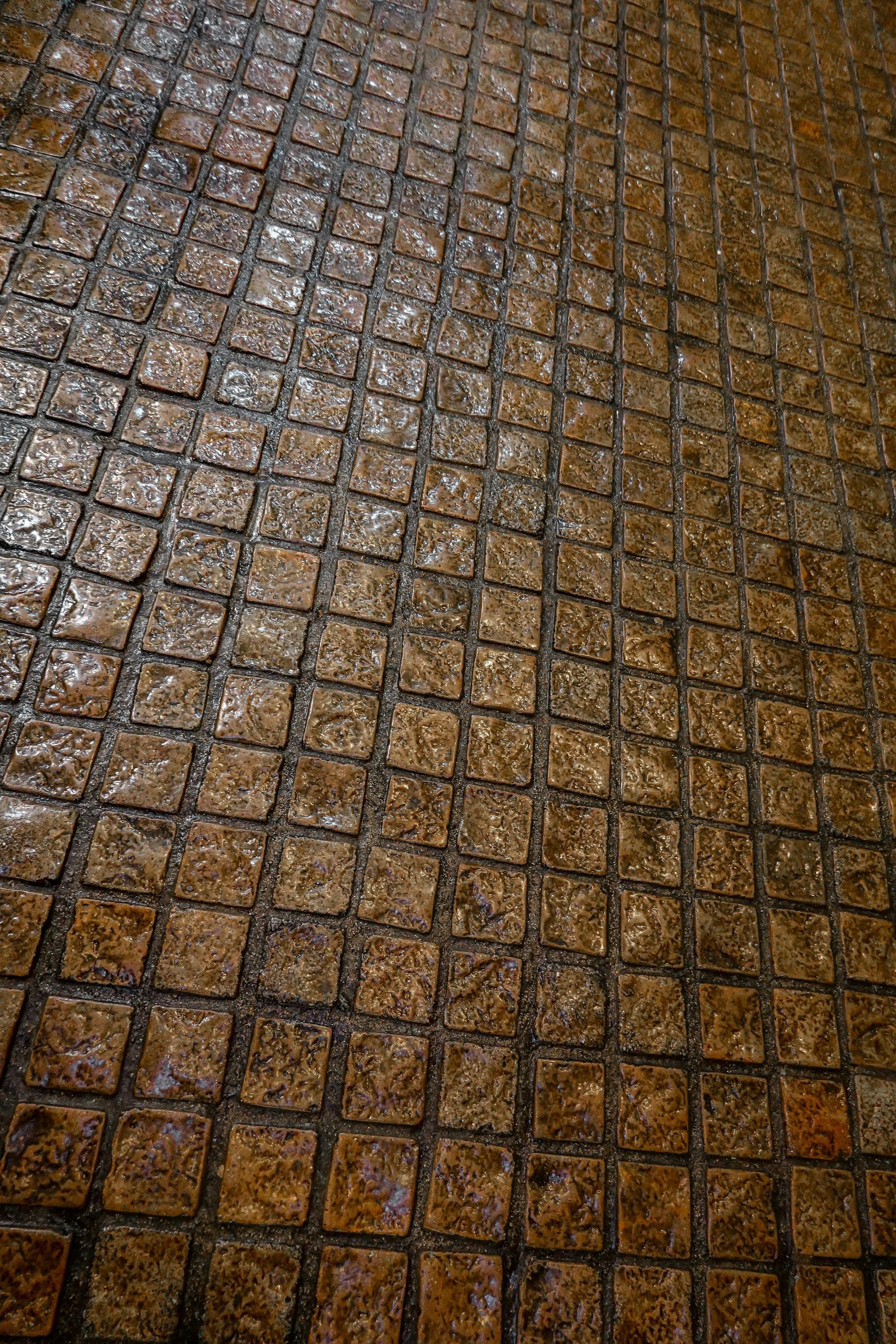 Construction workers pouring concrete on a road, wearing safety vests, boots, using shovels.