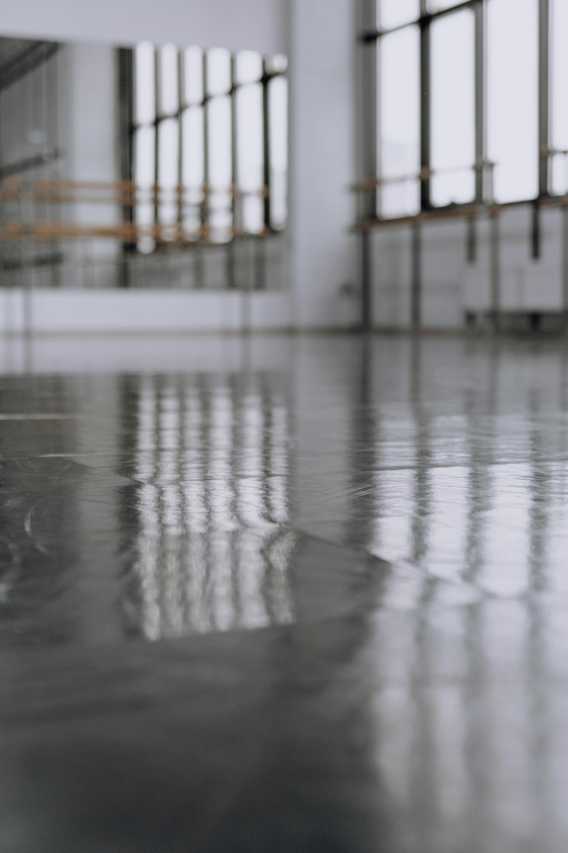 Workers smoothing wet concrete for a sidewalk with hand tools in an outdoor setting.