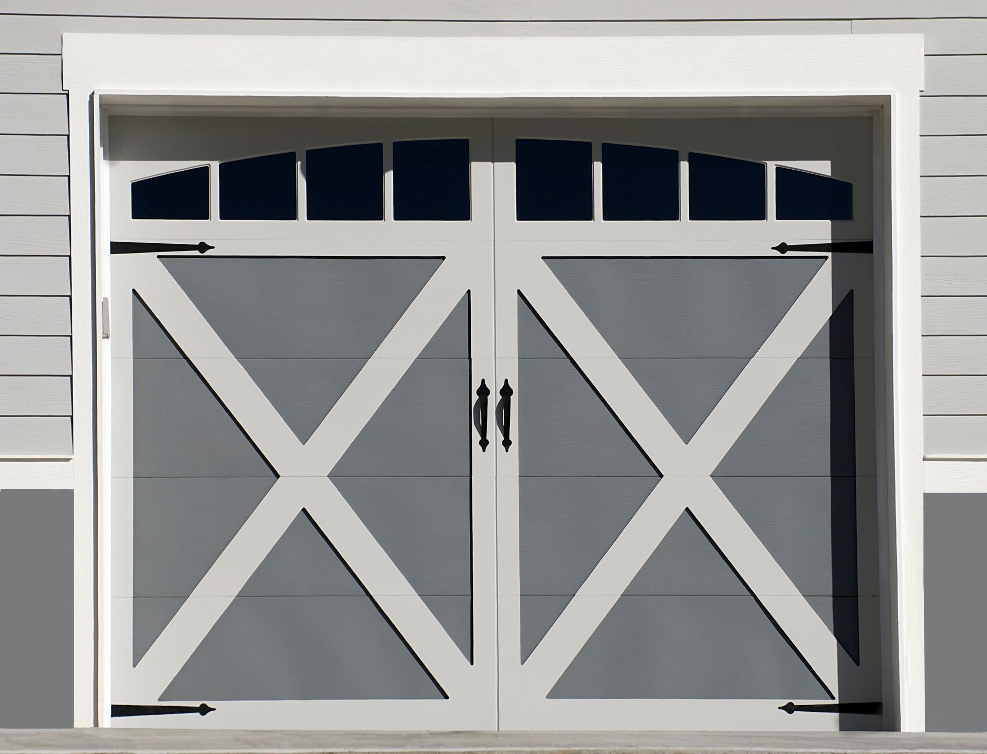 A white and gray garage door with black handles