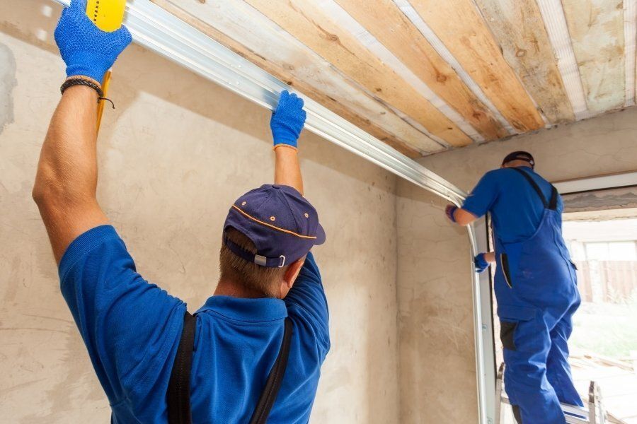 Garage door technicians repairing broken garage door rolls and tracks.