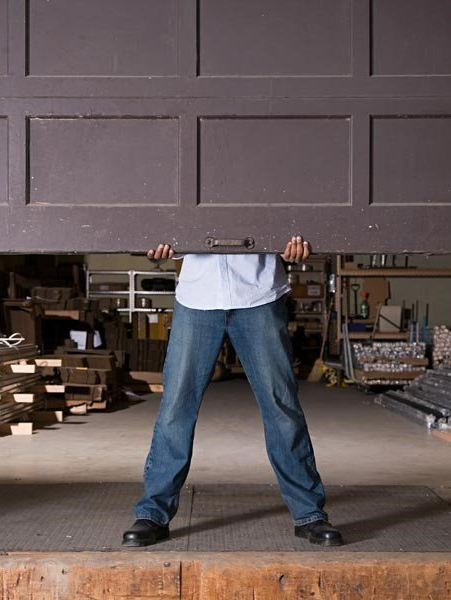 man lifting garage door because opener is broken