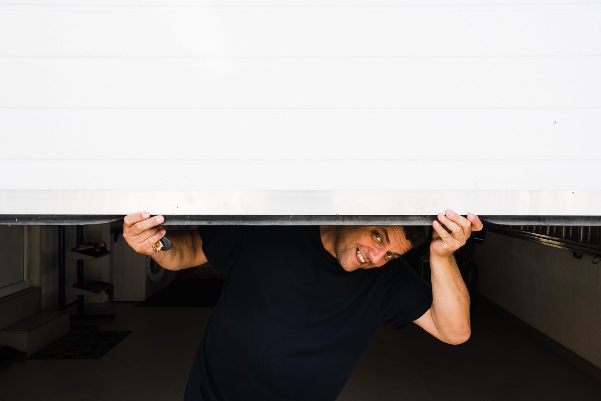 A man showing the camera how to manually open a garage door