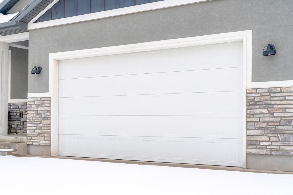 A white garage door is on the side of a house.