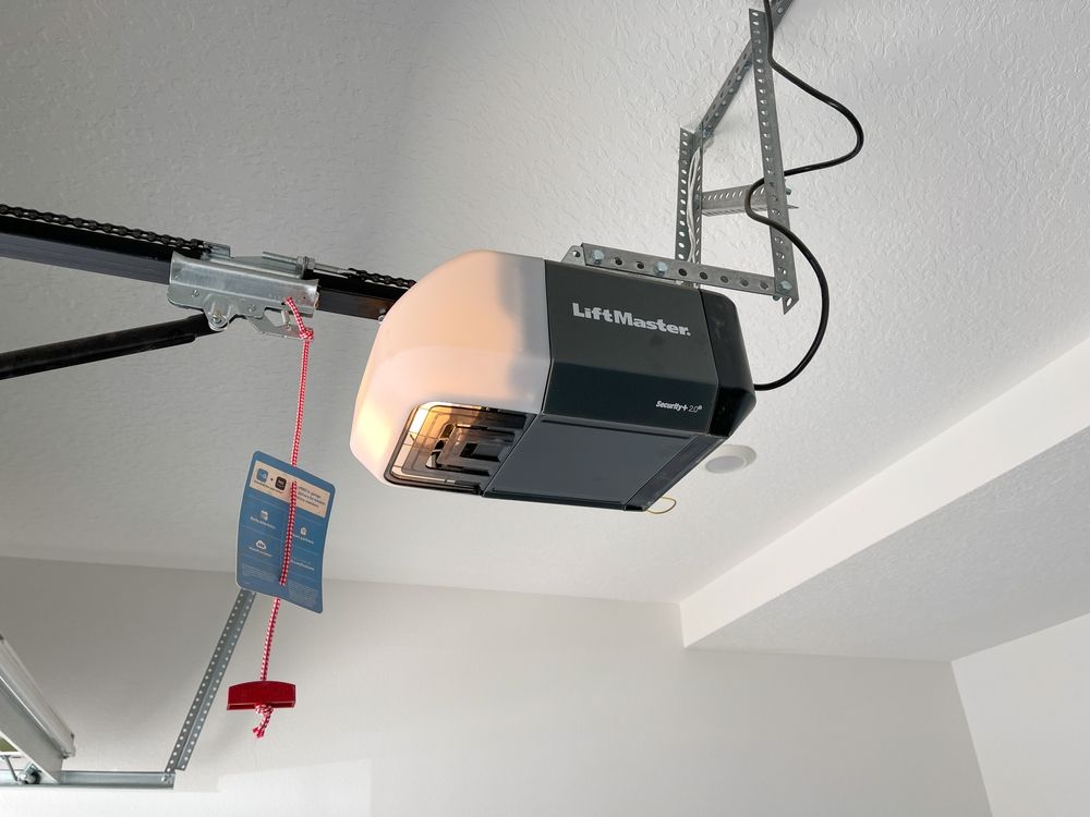 A liftmaster garage door opener is hanging from the ceiling