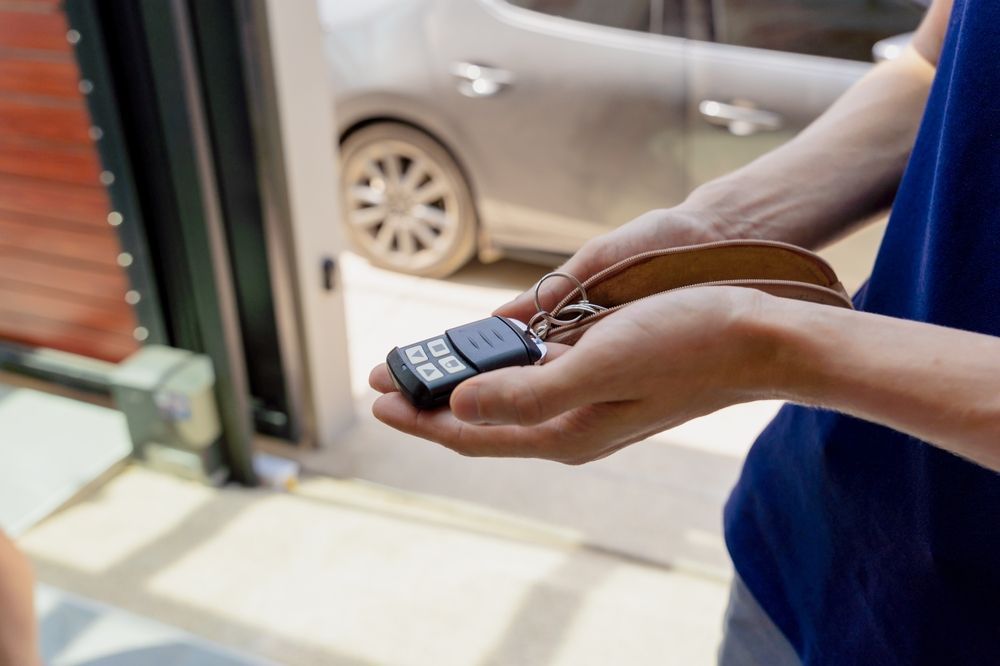 A person is holding a car key in their hands in front of a car.