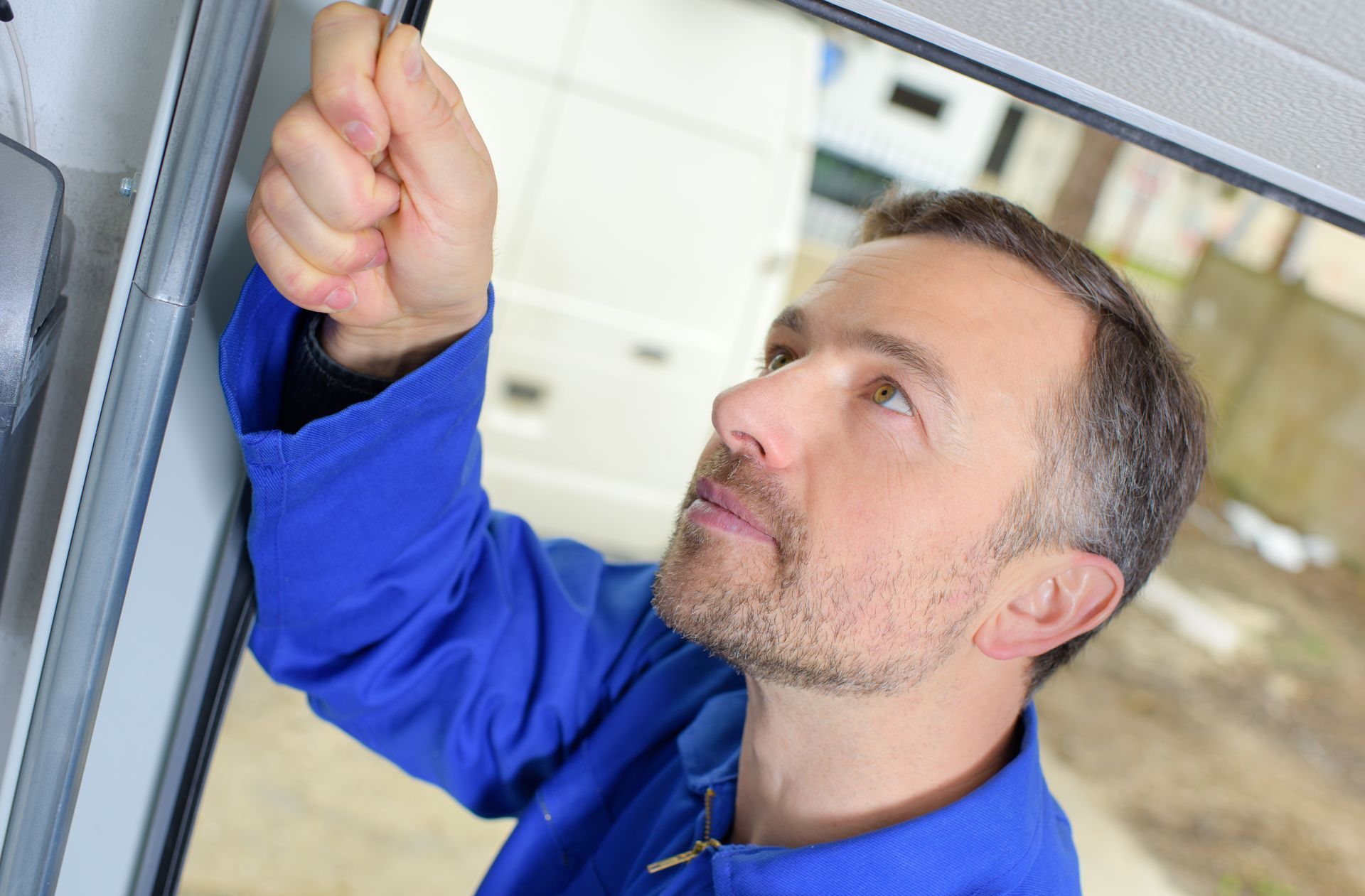 An Uplift Garage technician inspecting a C.H.I garage door.