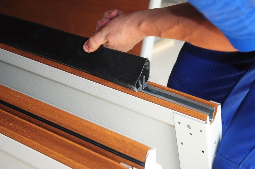 A man in a blue shirt is working on a piece of wood.