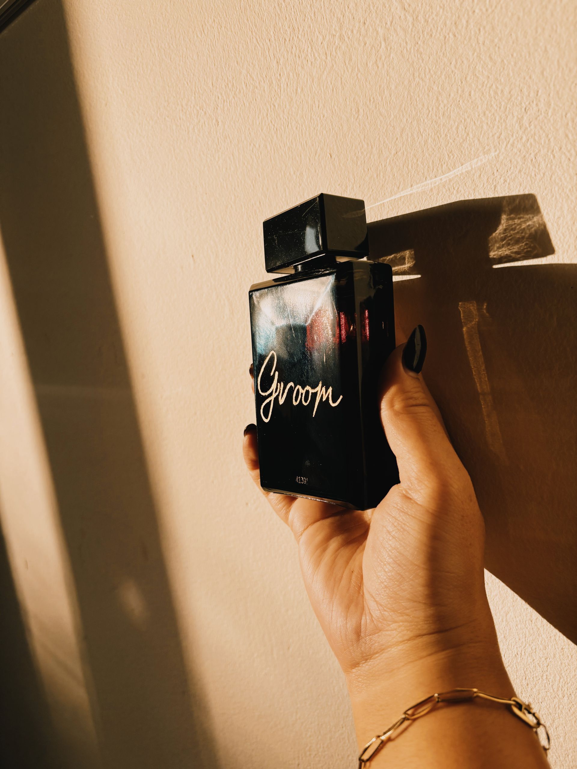 Een persoon houdt een fles bruidegomparfum vast