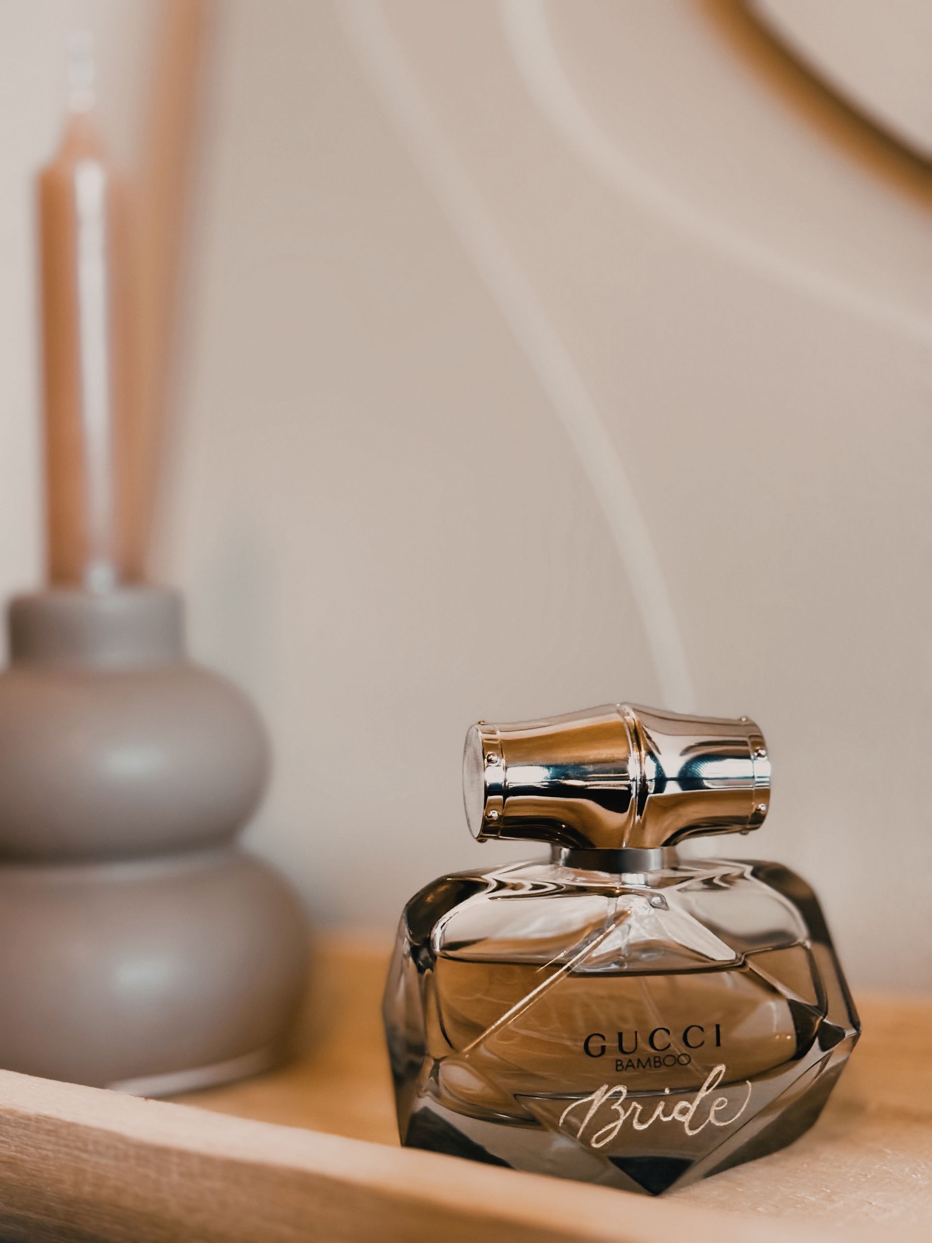 Een flesje Gucci bruidsparfum staat op een houten tafel.