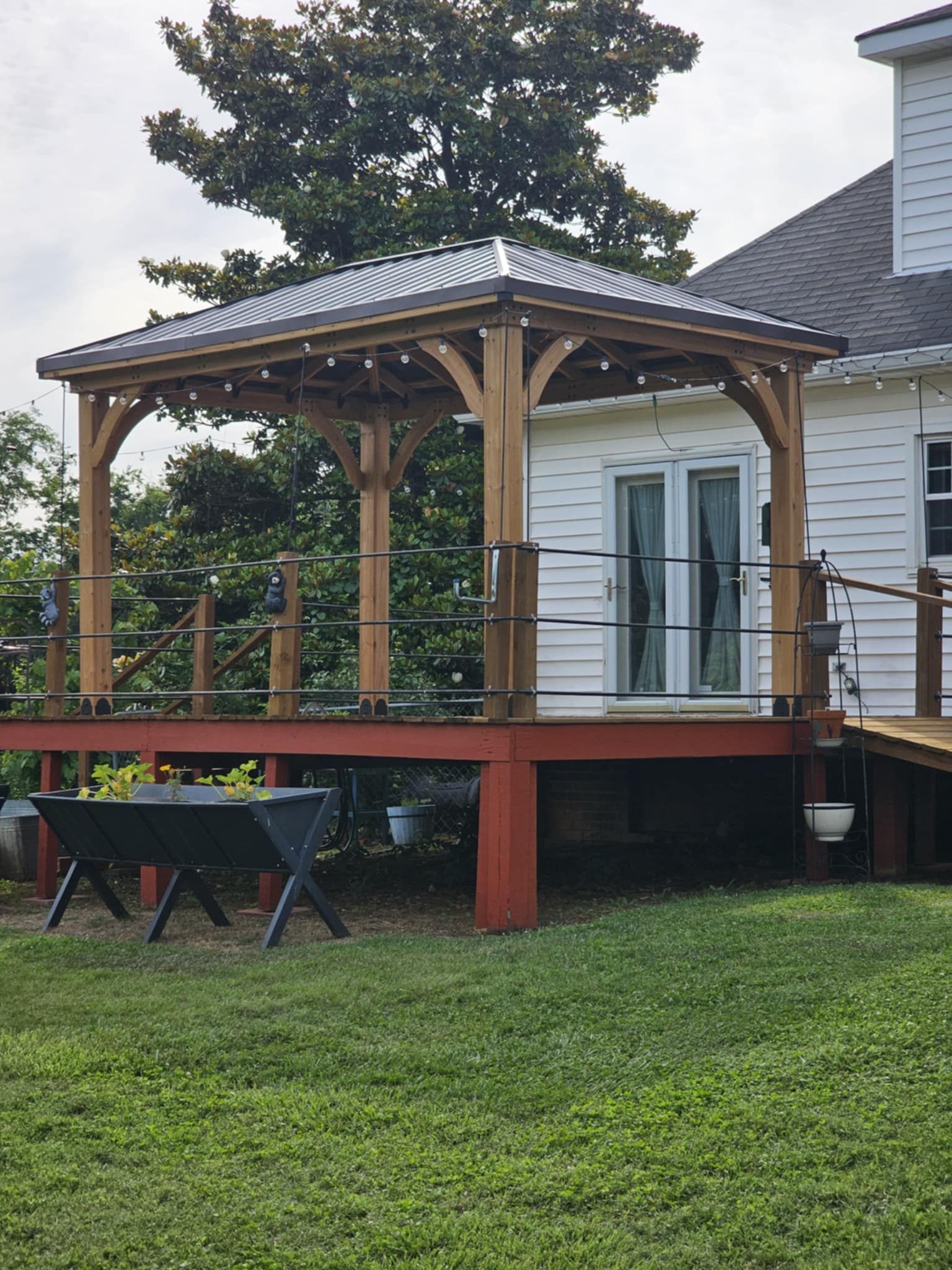 A white house with a wooden gazebo in front of it
