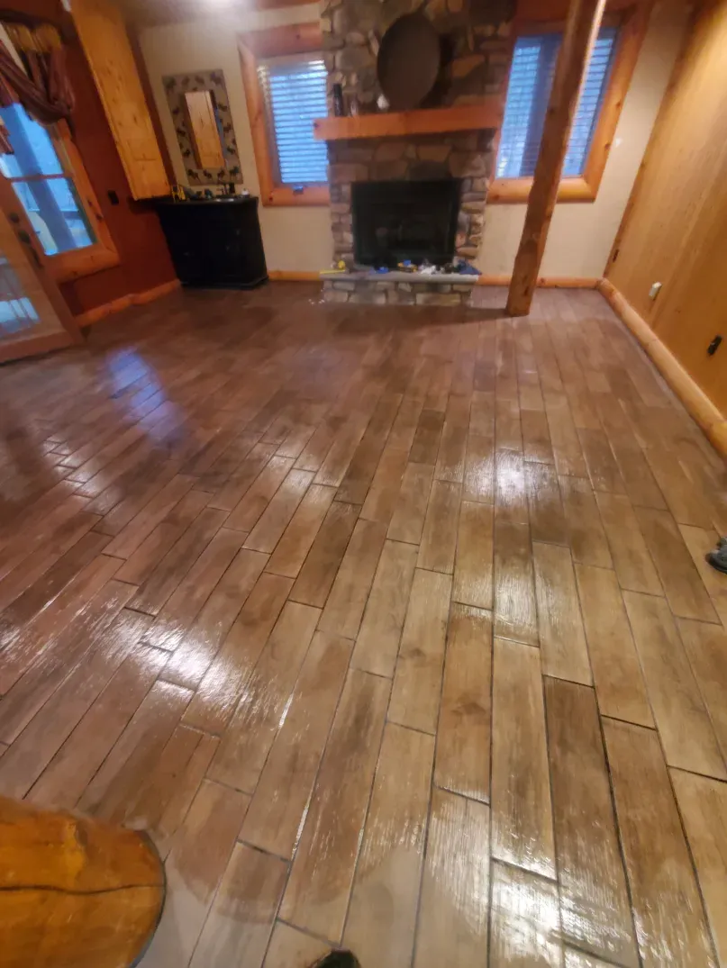 A living room with a wooden floor and a fireplace.