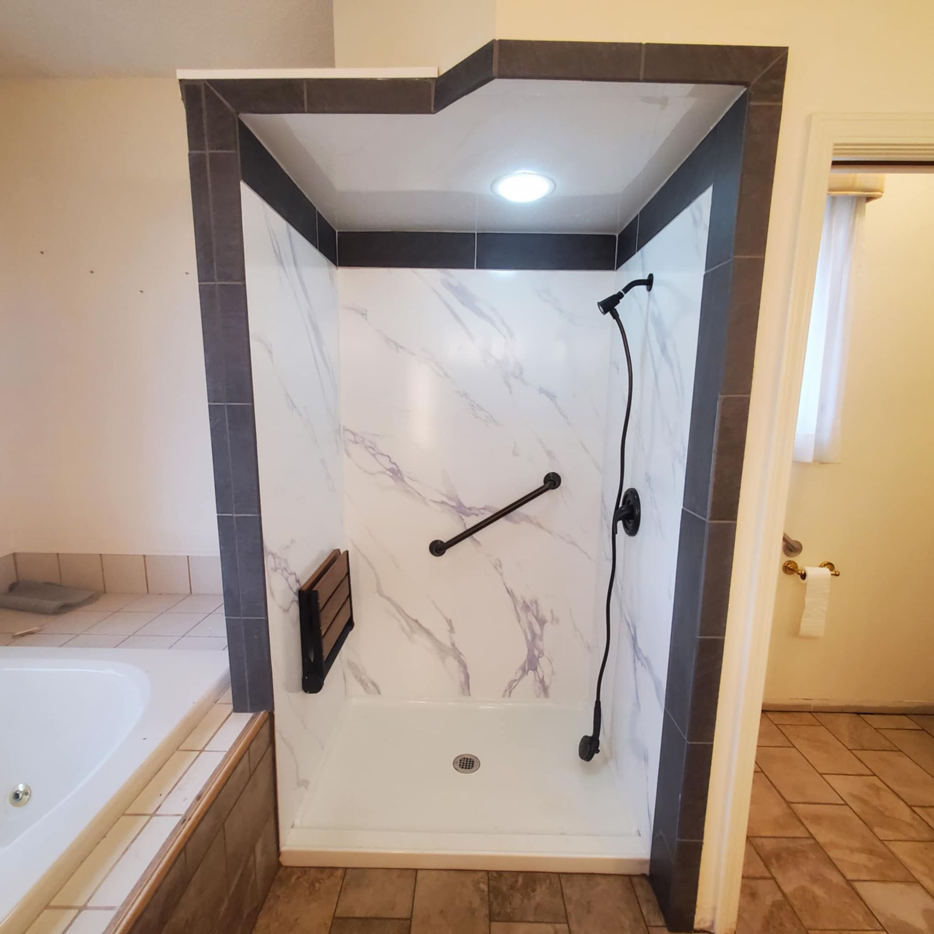 A bathroom with a walk in shower and a tub