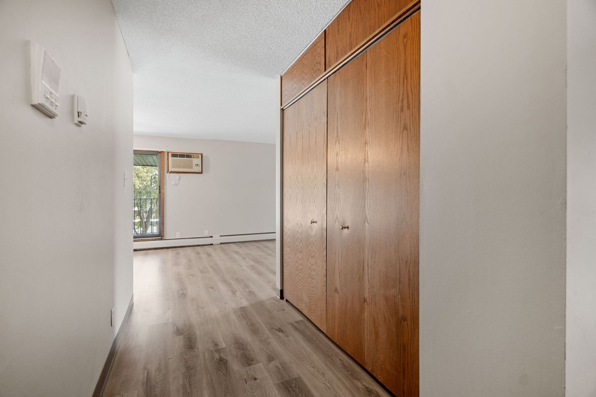 A hallway in a house with wooden floors and a balcony.