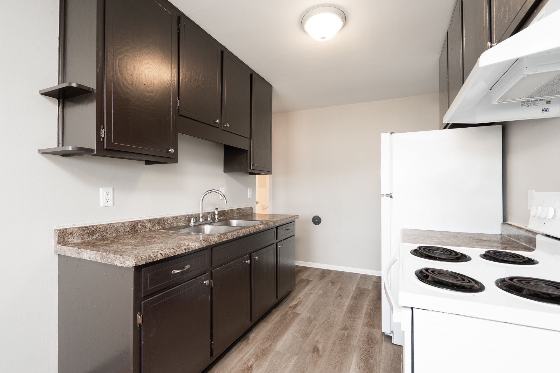 A kitchen with a sink , stove , refrigerator and dishwasher.