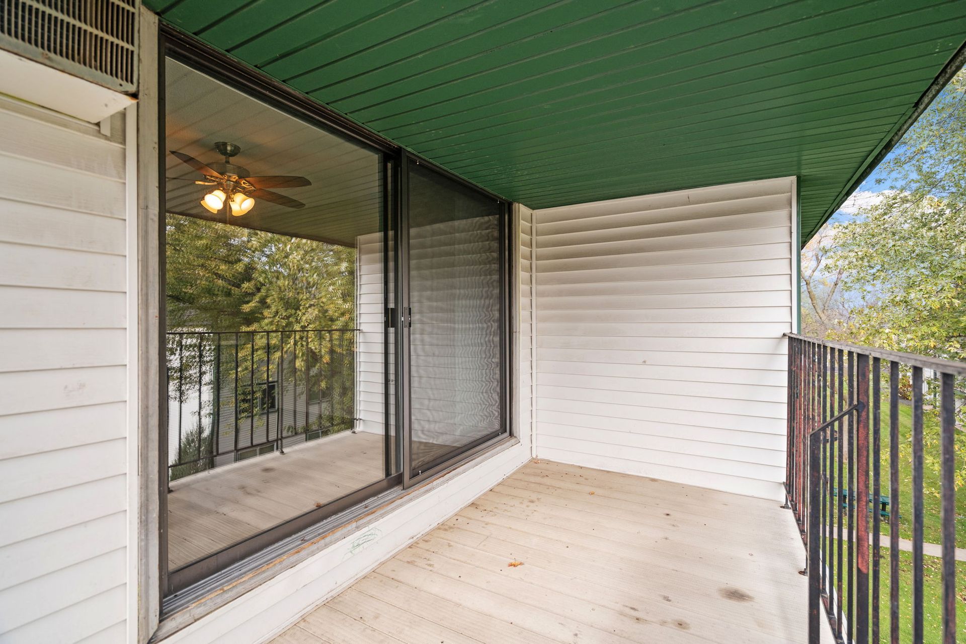 A balcony with sliding glass doors and a ceiling fan.
