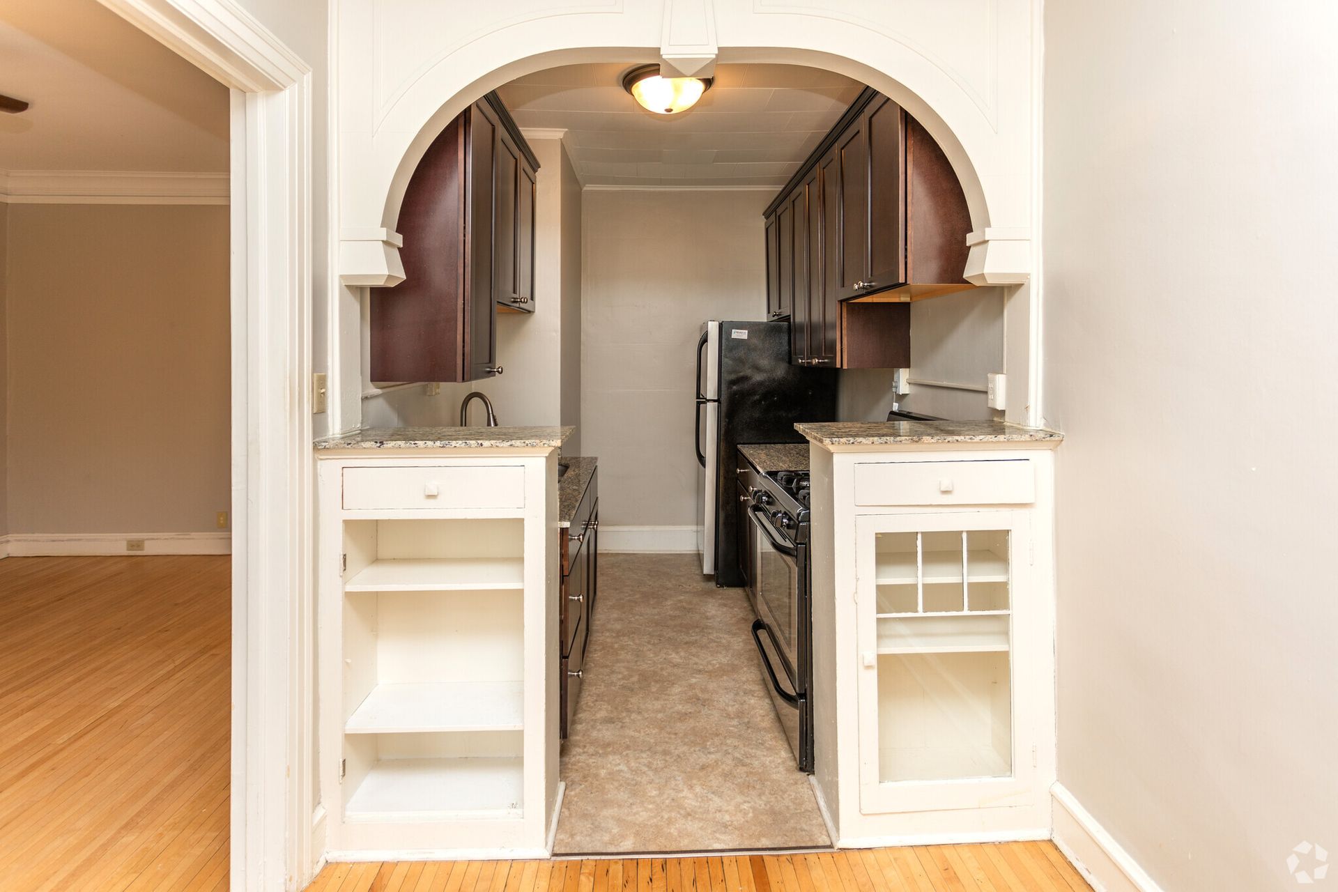 A kitchen with a refrigerator , stove , sink and cabinets.