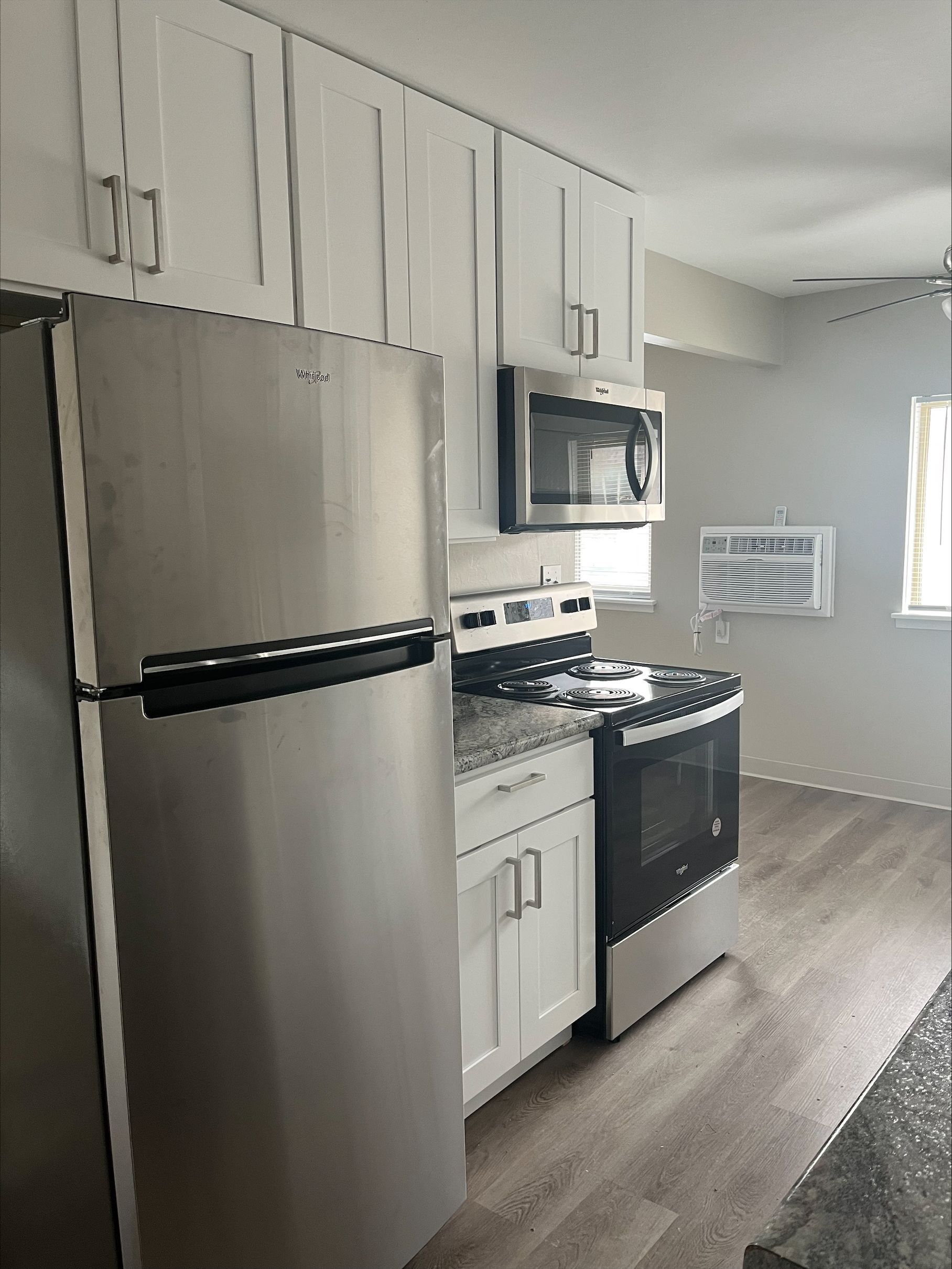 A kitchen with stainless steel appliances and white cabinets.
