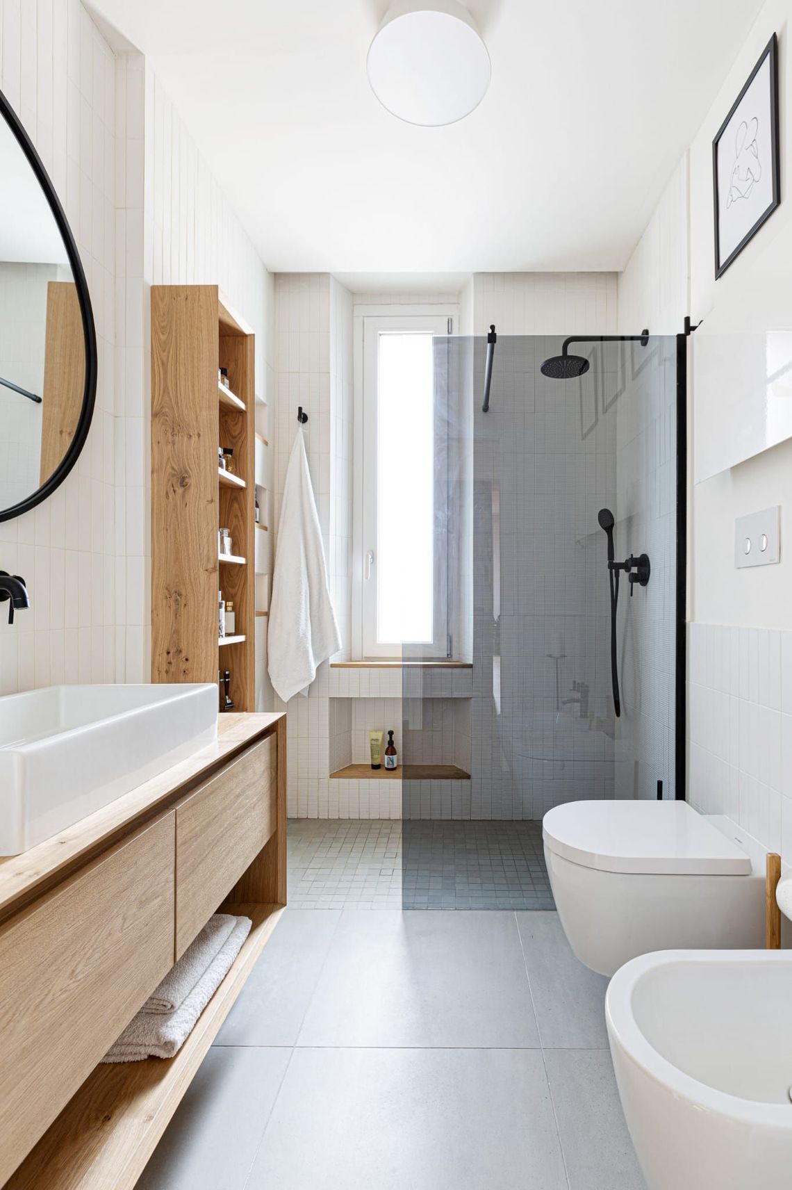Un bagno con lavandino, water, bidet e doccia.