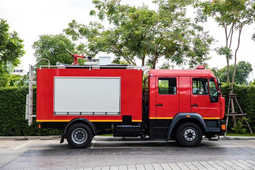 A Red Fire Truck Is Parked In A Parking Lot — ABC Driving School Central Coast In Umina Beach, NSW