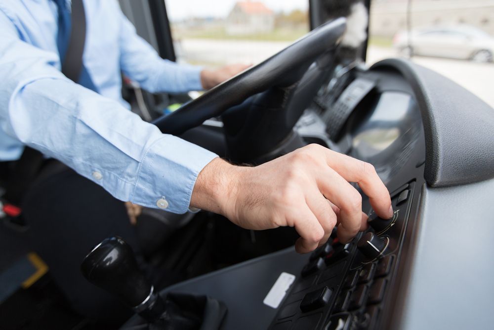 A Man Is Driving A Bus With His Hands On The Steering Wheel — ABC Driving School Central Coast In Umina Beach, NSW