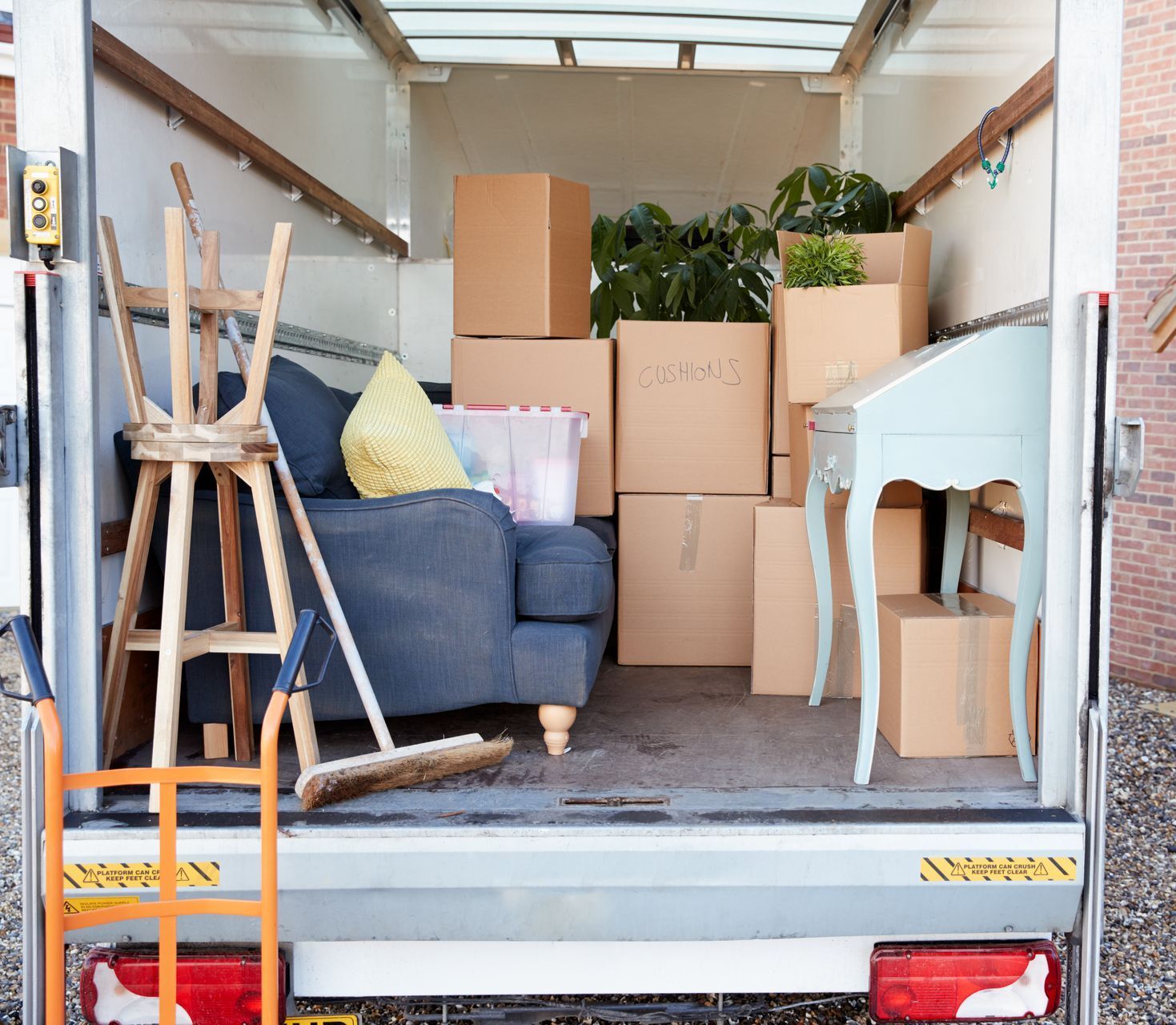 sul retro di un camion in movimento pieno di scatoloni e mobili