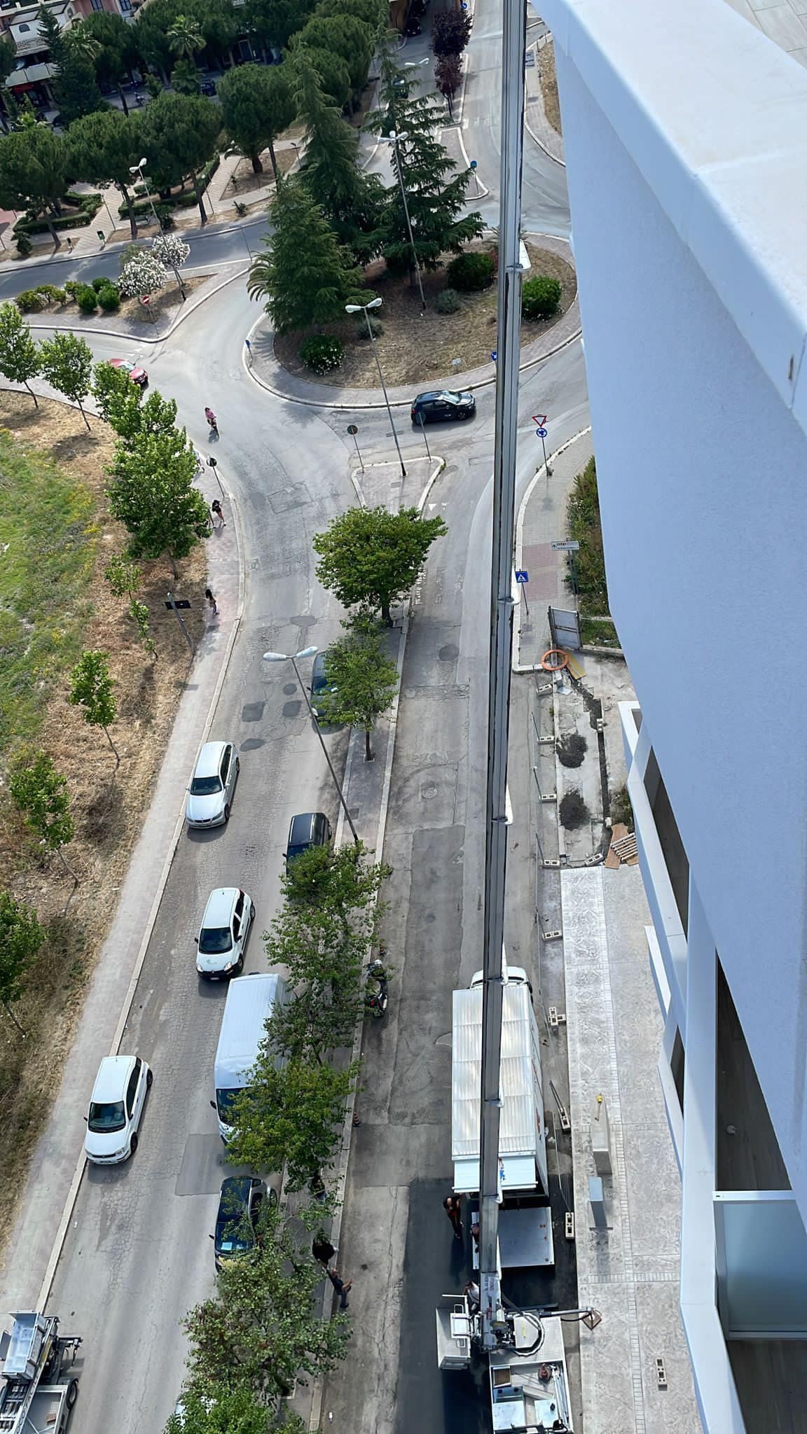 una veduta aerea di una strada cittadina con le auto che la percorrono.