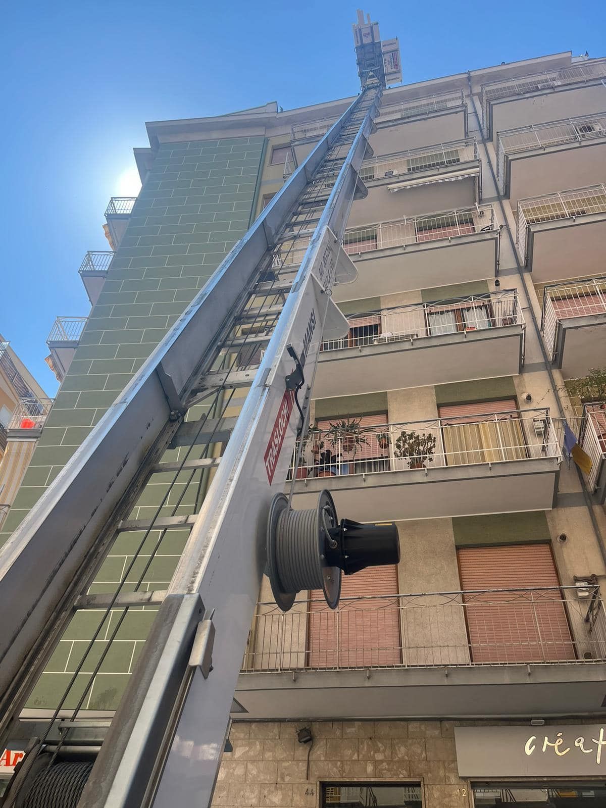 una grande gru è seduta in cima a un alto edificio.