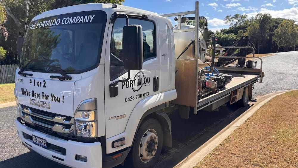 A White Tow Truck Is Parked On The Side Of The Road — The Portaloo Co in Dimbulah, QLD