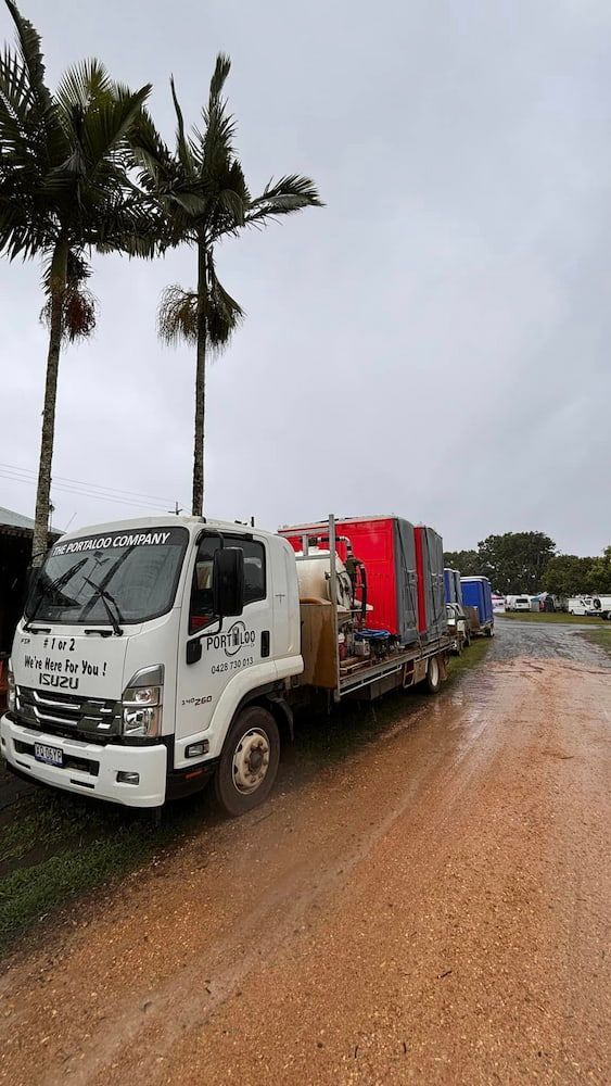 A White Truck Is Parked On The Side Of A Dirt Road Next To Palm Trees — The Portaloo Co in Dimbulah, QLD