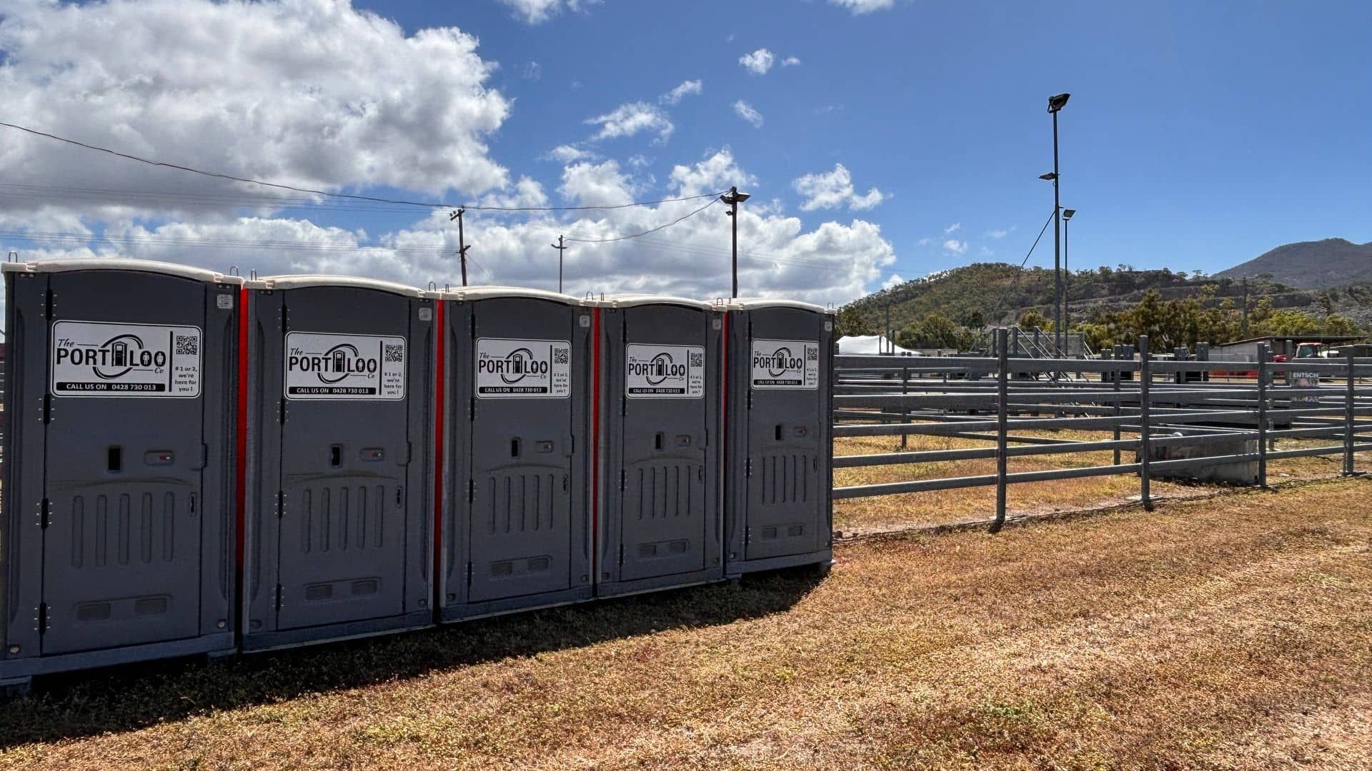 A Green Portable Toilet Is Sitting In The Middle Of A Grassy Field — The Portaloo Co in Dimbulah, QLD