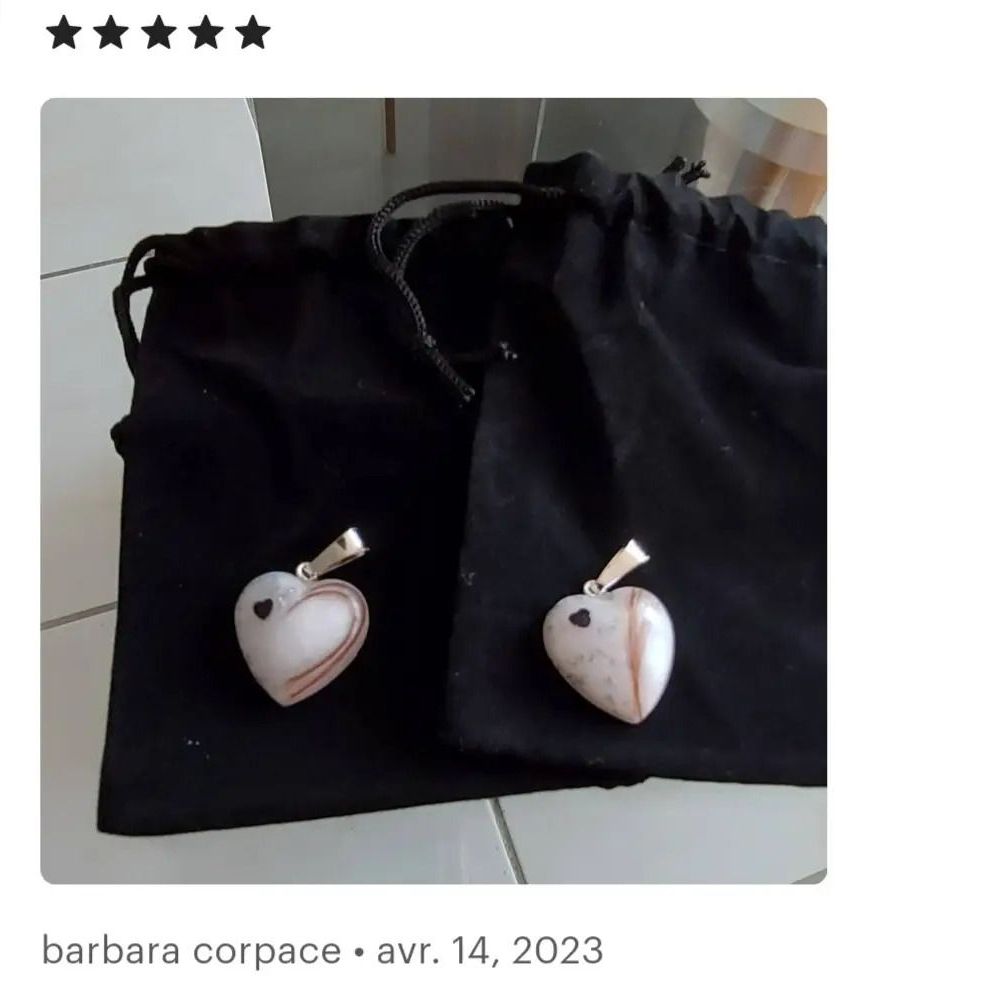 Deux pendentifs en forme de coeur sont sur un sac noir