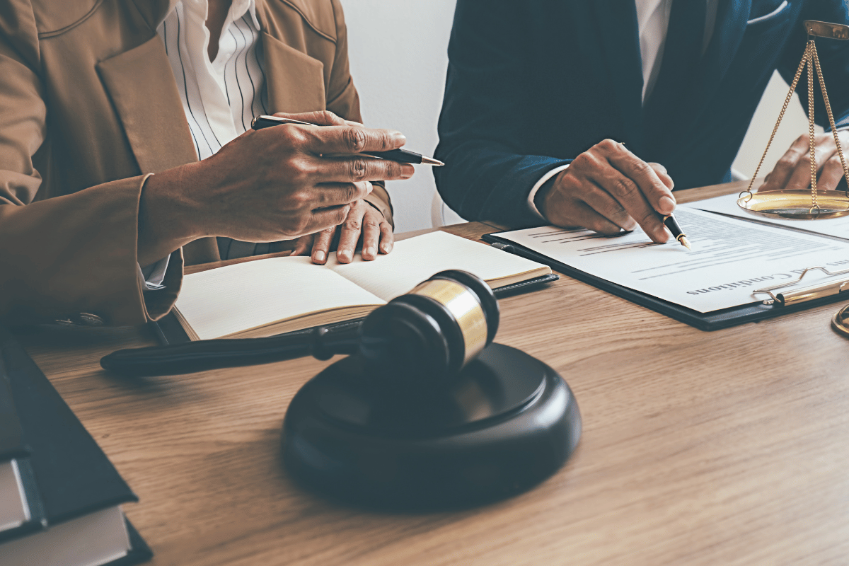 Beige two-story house with black roof and stone accents, two-car garage, on a lawn with a cloudy sunset.