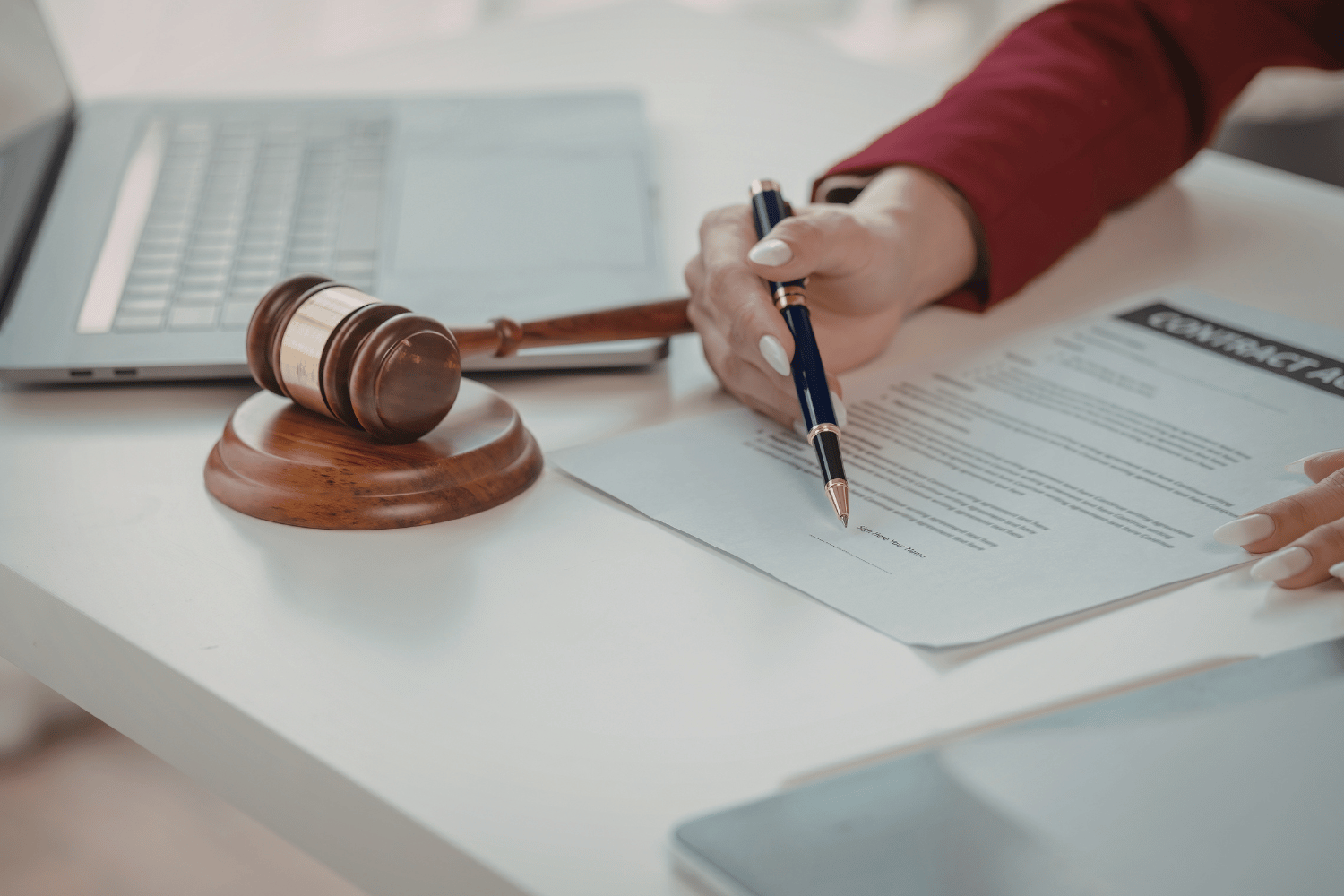 Beige two-story house with black roof and stone accents, two-car garage, on a lawn with a cloudy sunset.