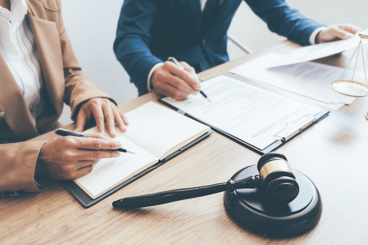 Beige two-story house with black roof and stone accents, two-car garage, on a lawn with a cloudy sunset.