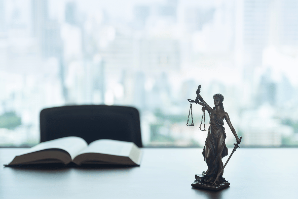 Aerial view of a suburban neighborhood with houses, a road, trees, and a lake.