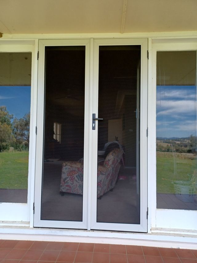 A Pair of Sliding Glass Doors Leading Into a Living Room — BTS Blinds & Awnings in Gunnedah, NSW