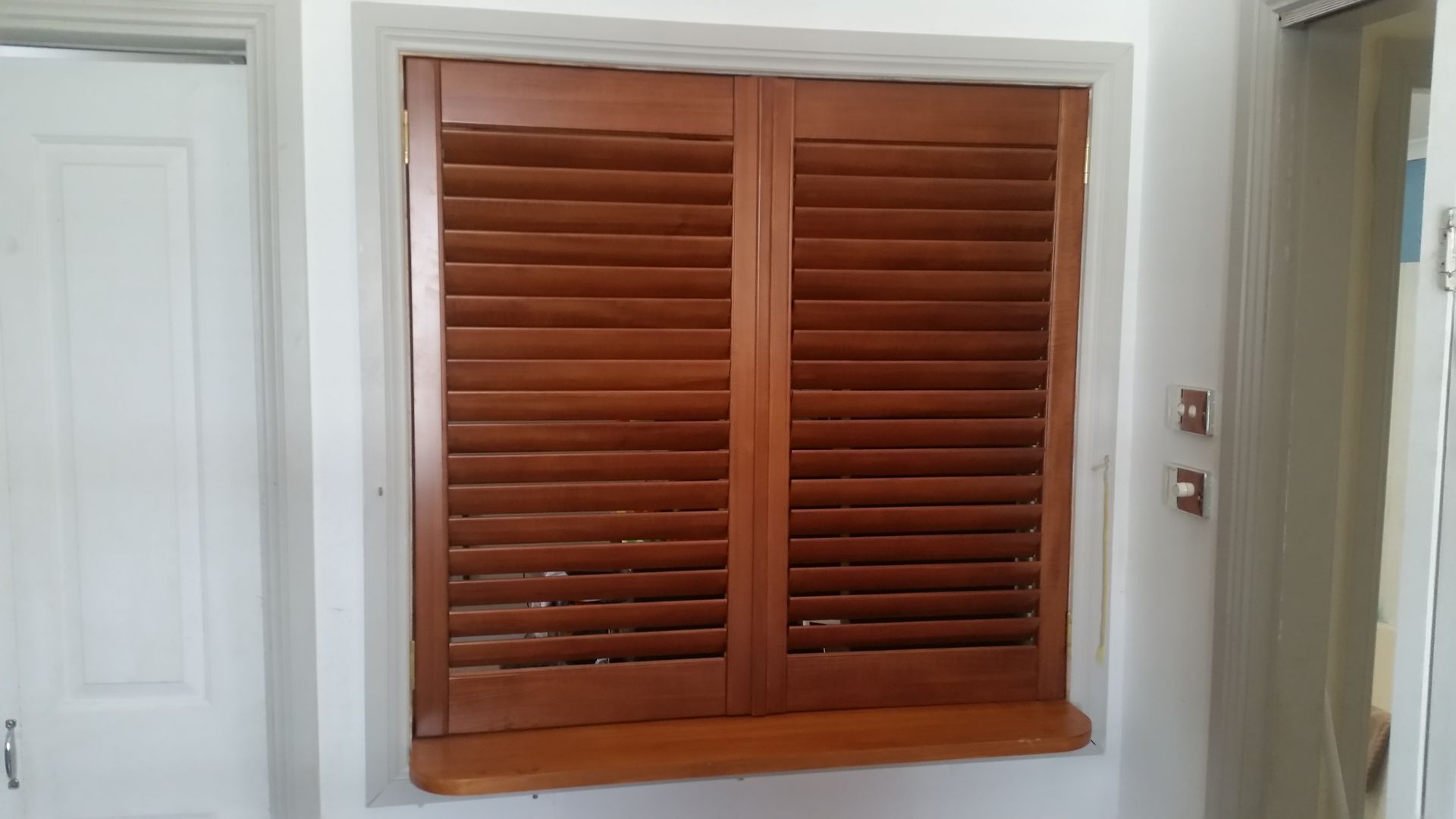 A Window With Wooden Shutters on It in a Room — BTS Blinds & Awnings in Gunnedah, NSW