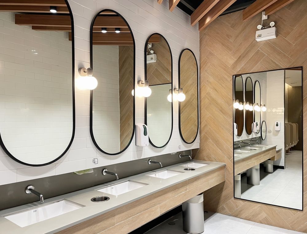 Public restroom with oval mirrors, sinks, and wood paneling.