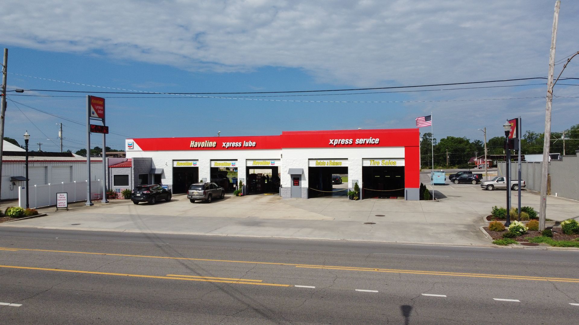 A red and white tire shop with cars parked in front of it