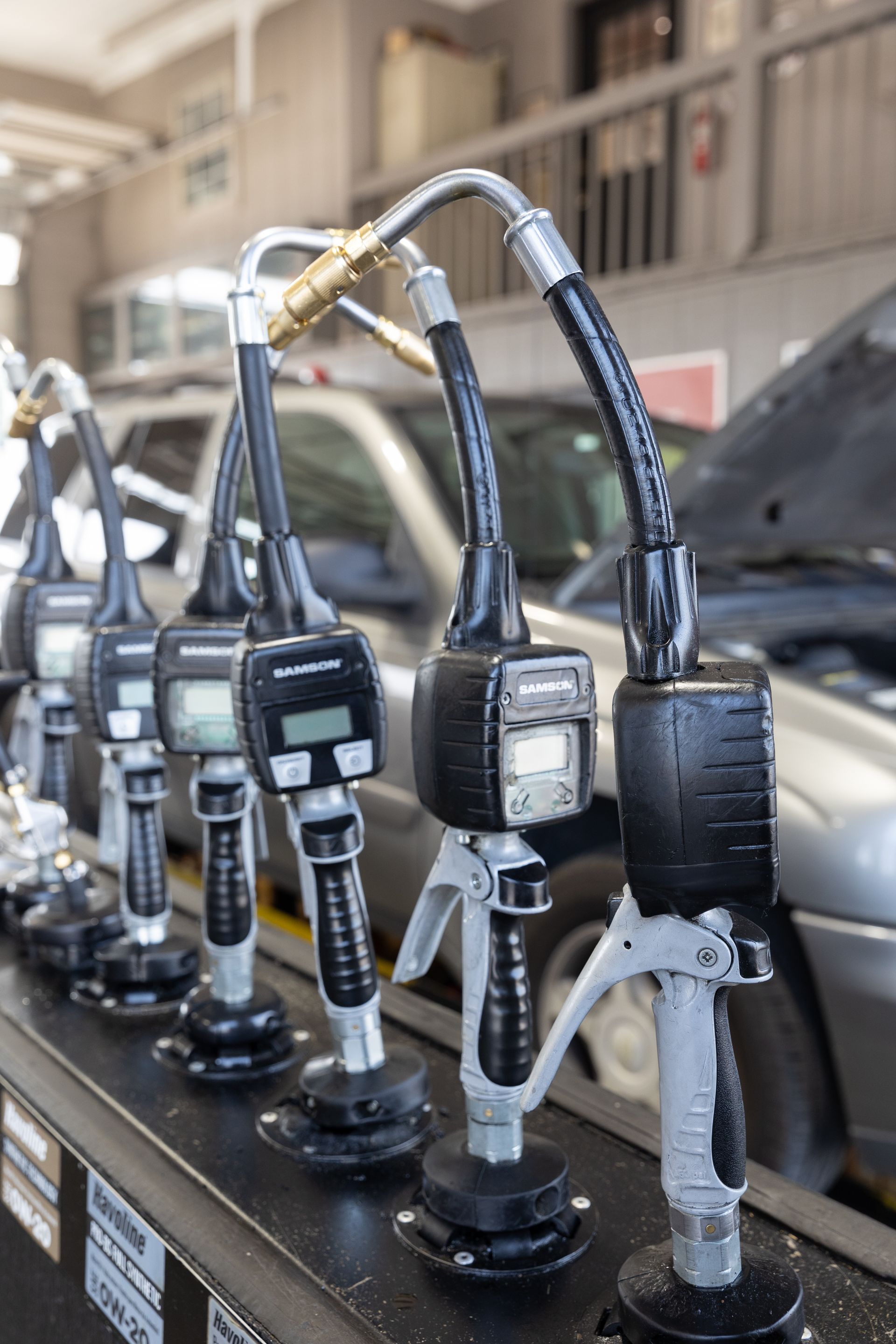 A group of men are working on a car in a garage.