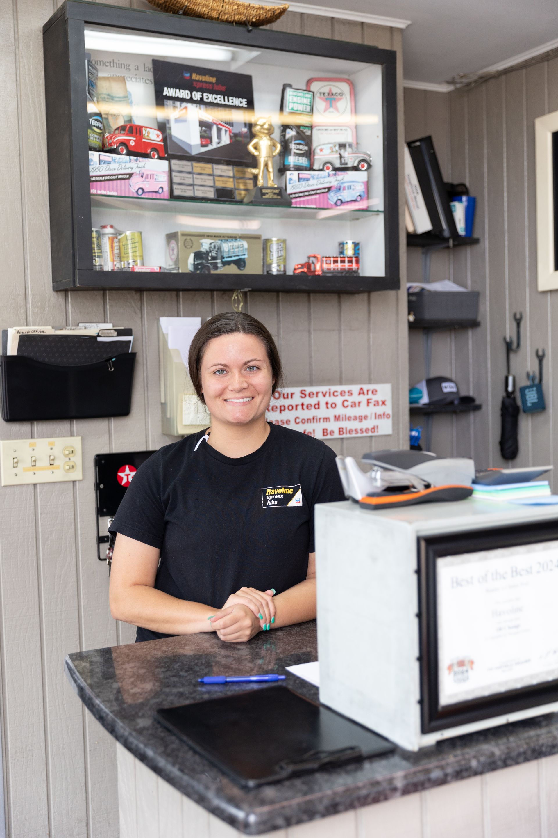A woman is standing in front of a counter in a gas station.