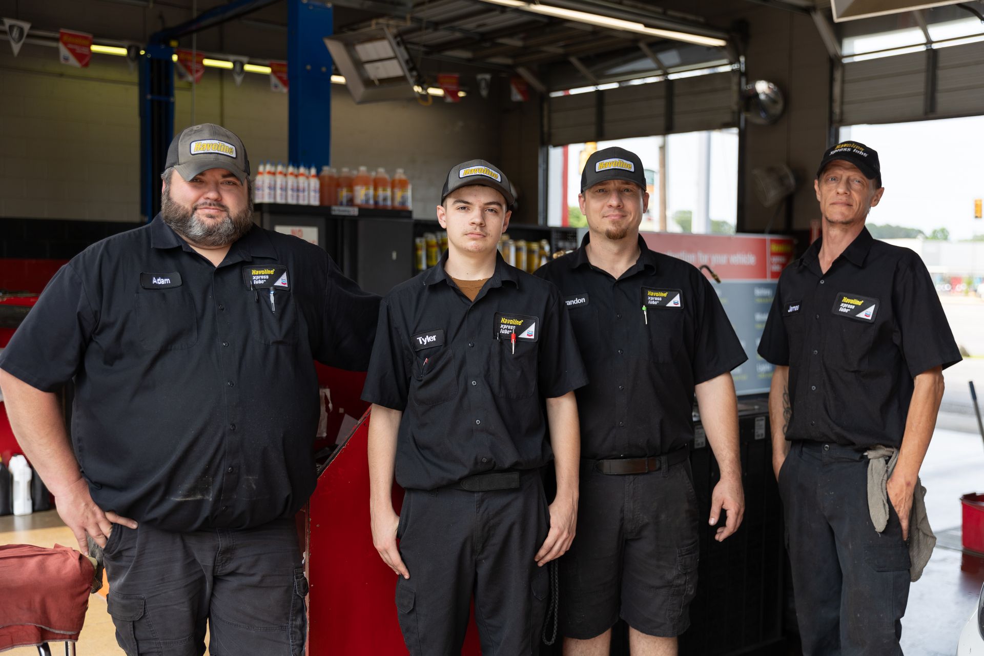 Two men are standing in front of a garage door.