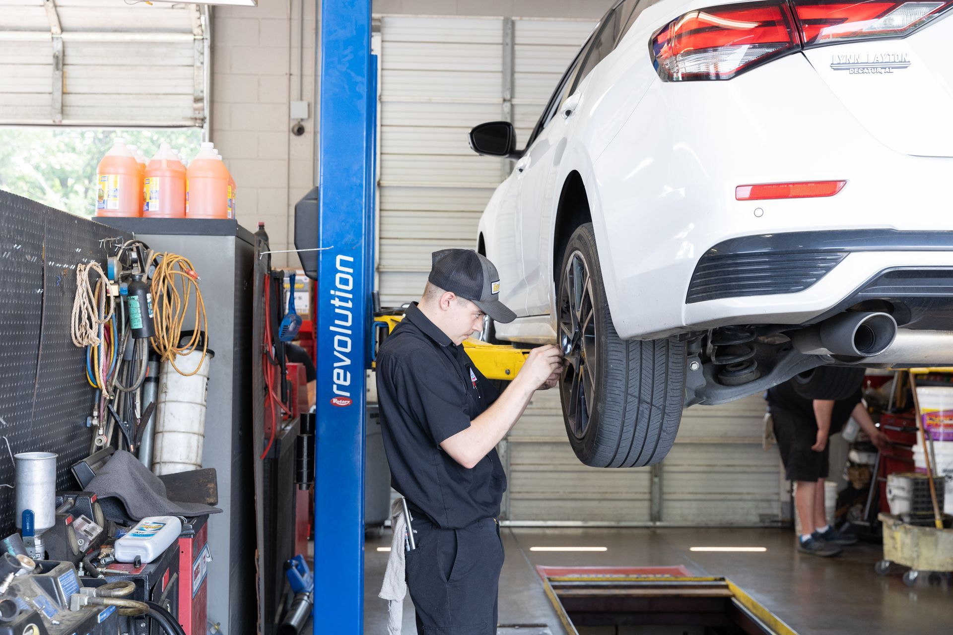 A white truck is sitting on a lift in a garage.
