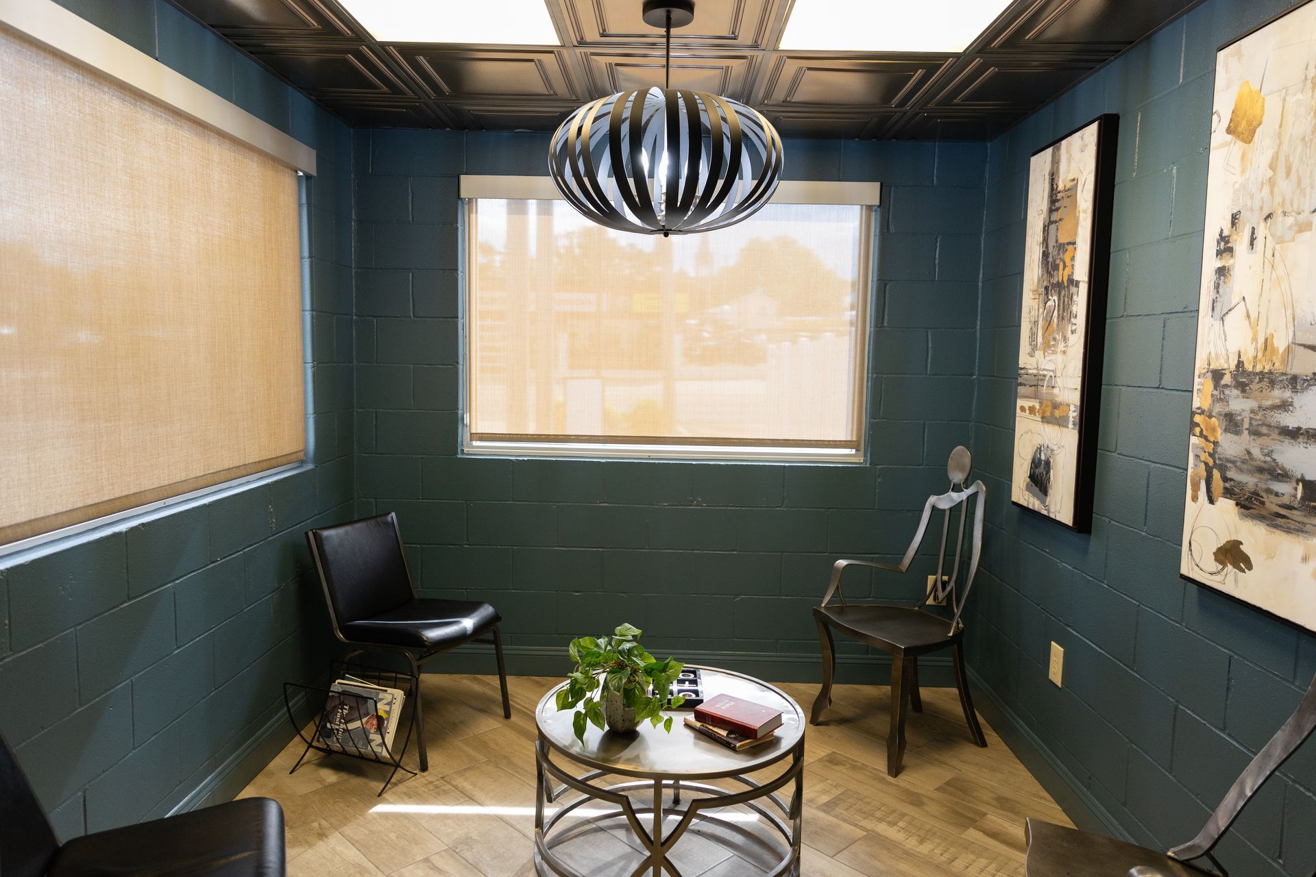 A waiting room with a table and chairs and a chandelier hanging from the ceiling.