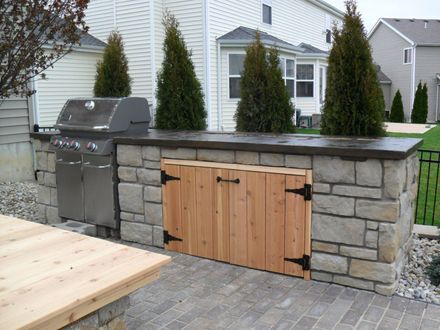 An Outdoor Kitchen with A Grill and A Wooden Table | Pacific, MO | CraftMasters