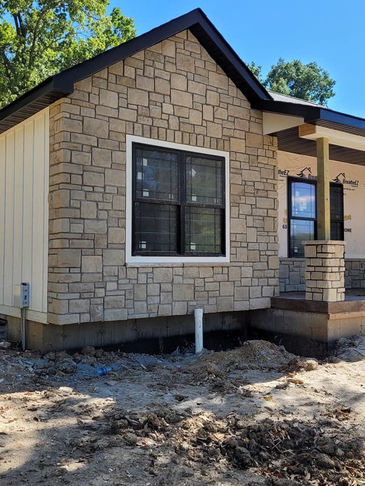 A small house with a stone facade is being built.