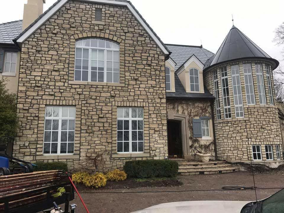 A large stone house with a car parked in front of it.