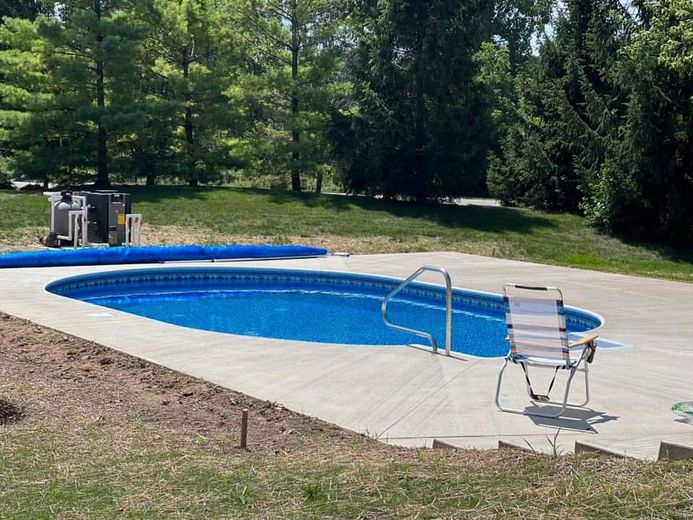 A swimming pool with a chair in front of it